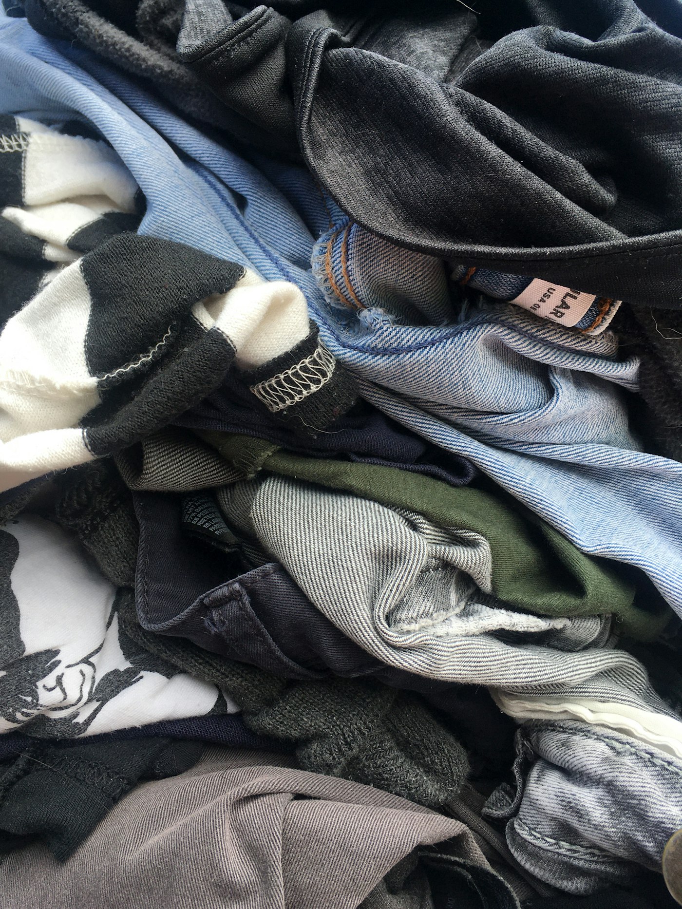 Pile of discarded clothing and denim